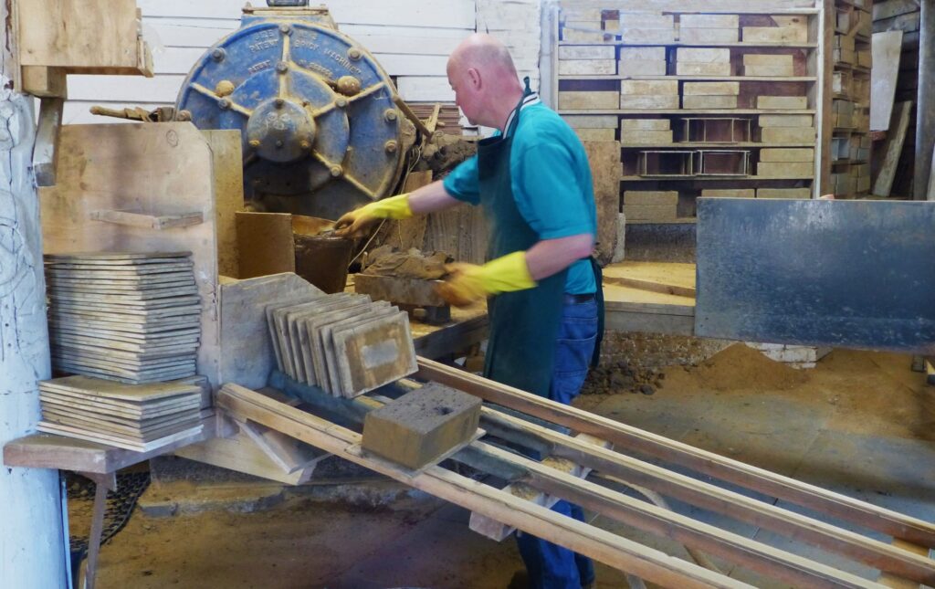 man operating a brick making press